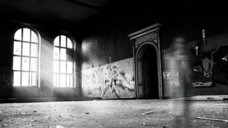 grayscale photo of person standing inside building