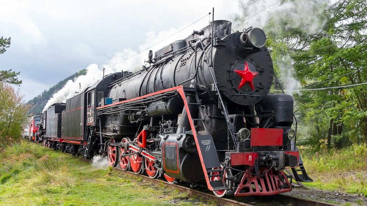 a black and red train traveling down train tracks