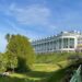 a large white building sitting on top of a lush green hillside