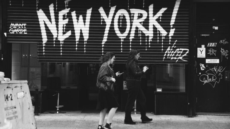grayscale photography of two women walking